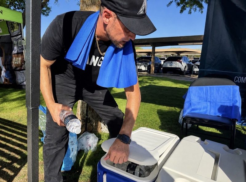 A Hydrate PHX volunteer loads bottled water into a cooler before the event begins.